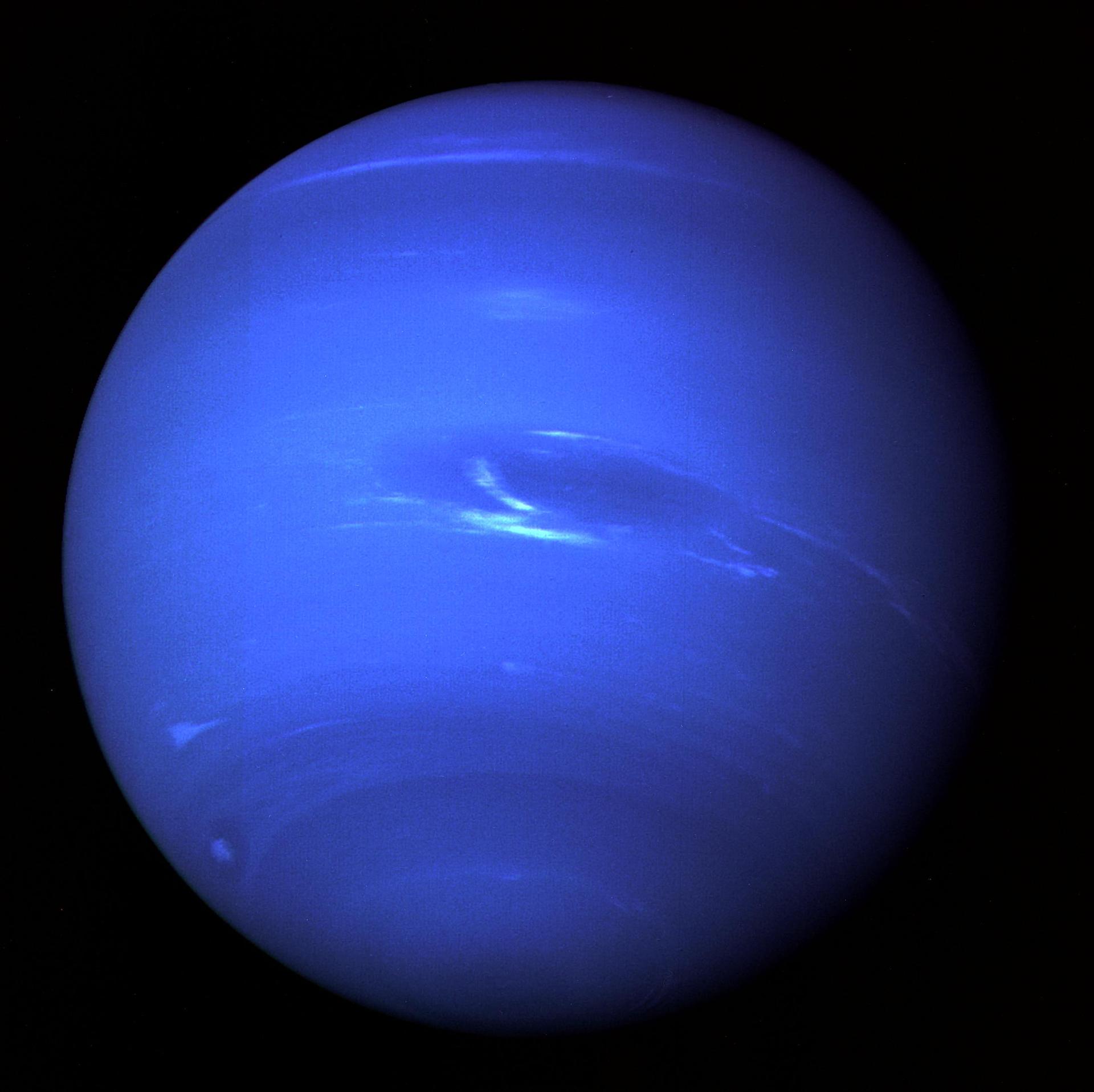 Neptune as seen by Voyager 2 showing the Great Dark Spot and bright cloud features